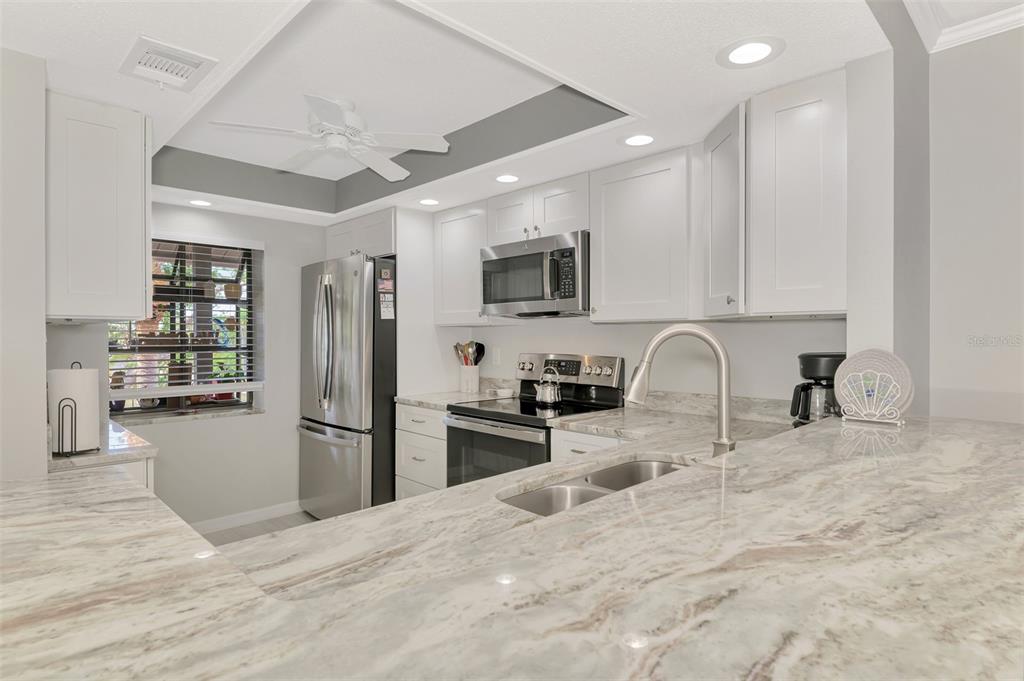 285 Mission Trail West, Unit B Venice, FL 34285 - Photo 11 of 49 a kitchen with stainless steel appliances granite countertop a refrigerator sink and stove