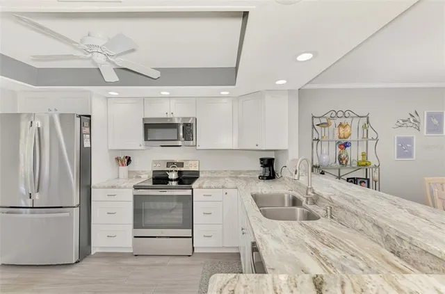 a kitchen with granite countertop a refrigerator stove and sink