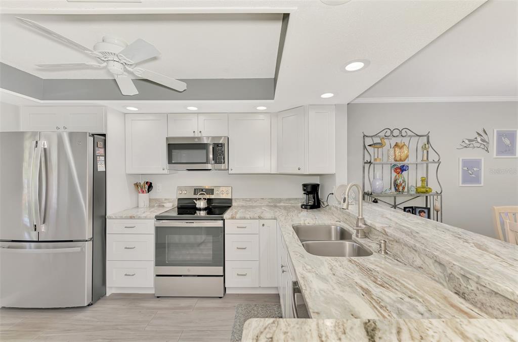 285 Mission Trail West, Unit B Venice, FL 34285 - Photo 14 of 49 a kitchen with granite countertop a refrigerator stove and sink