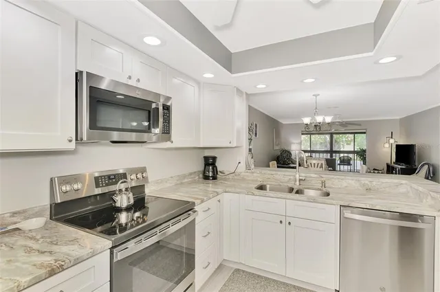 a kitchen with sink a microwave and cabinets
