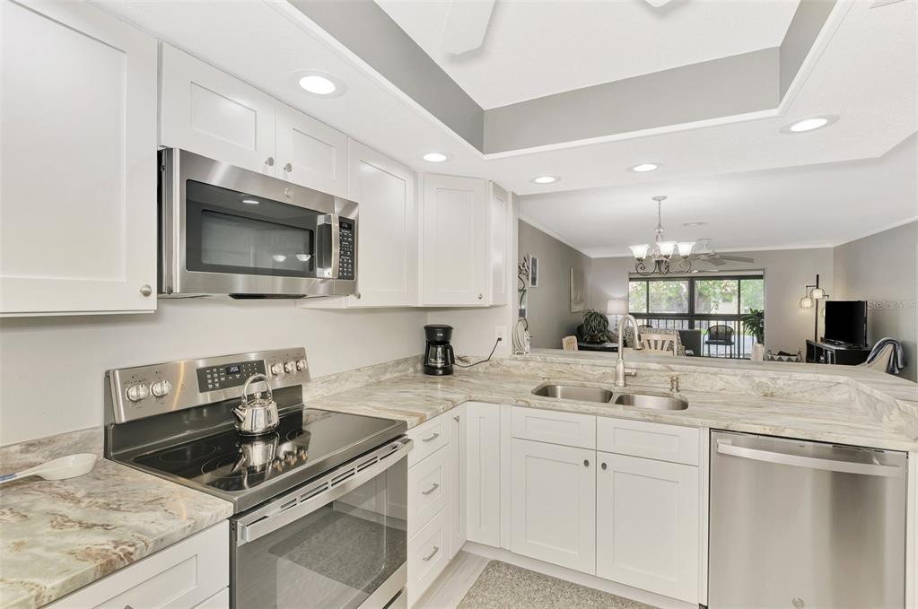 285 Mission Trail West, Unit B Venice, FL 34285 - Photo 17 of 49 a kitchen with sink a microwave and cabinets