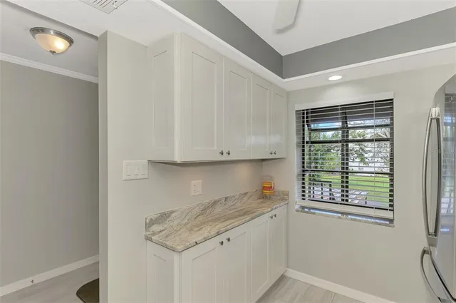 a kitchen with granite countertop white cabinets and a window