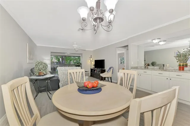 a view of a dining room with furniture a chandelier and wooden floor