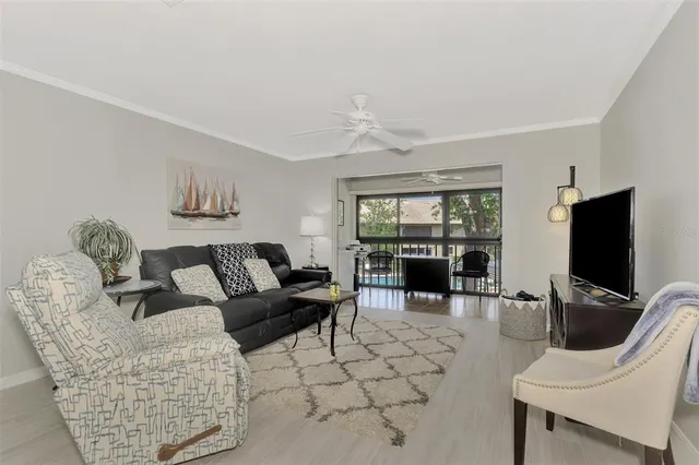 a living room with furniture a floor to ceiling window and a flat screen tv