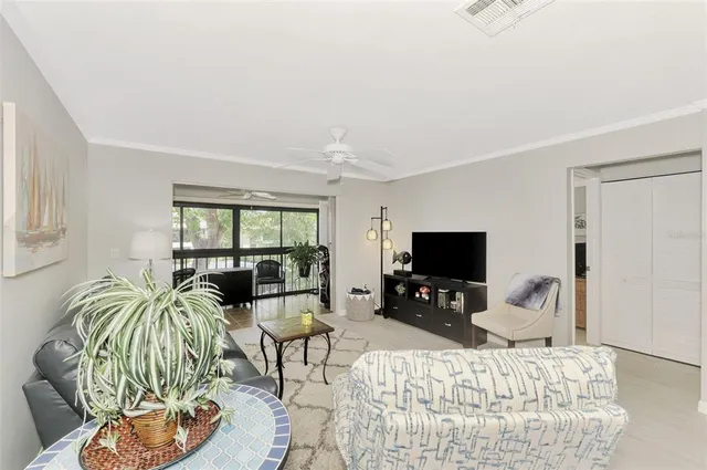 a living room with furniture a flat screen tv and a large window