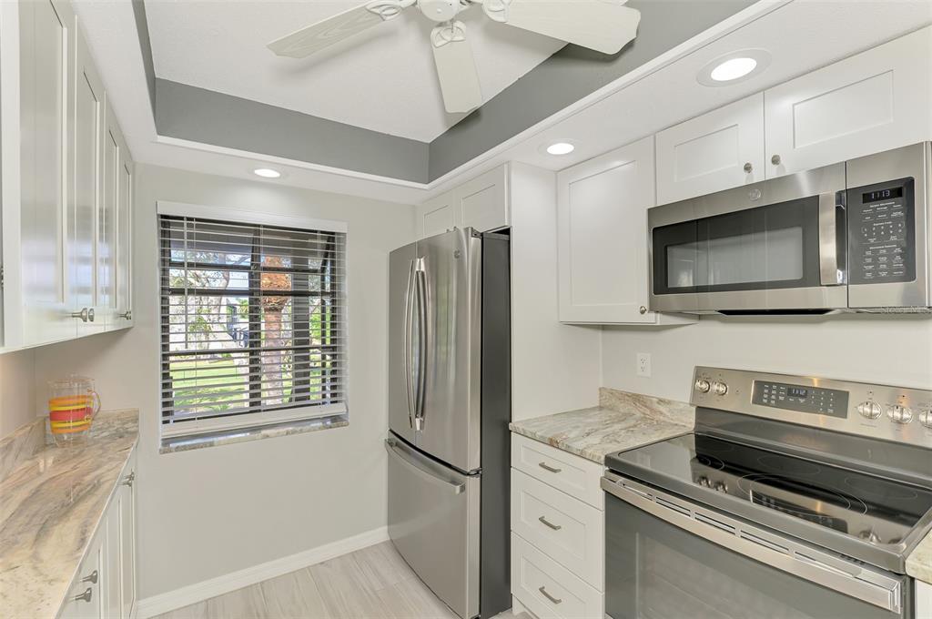 285 Mission Trail West, Unit B Venice, FL 34285 - Photo 7 of 49 a kitchen with stainless steel appliances a refrigerator and a stove top oven