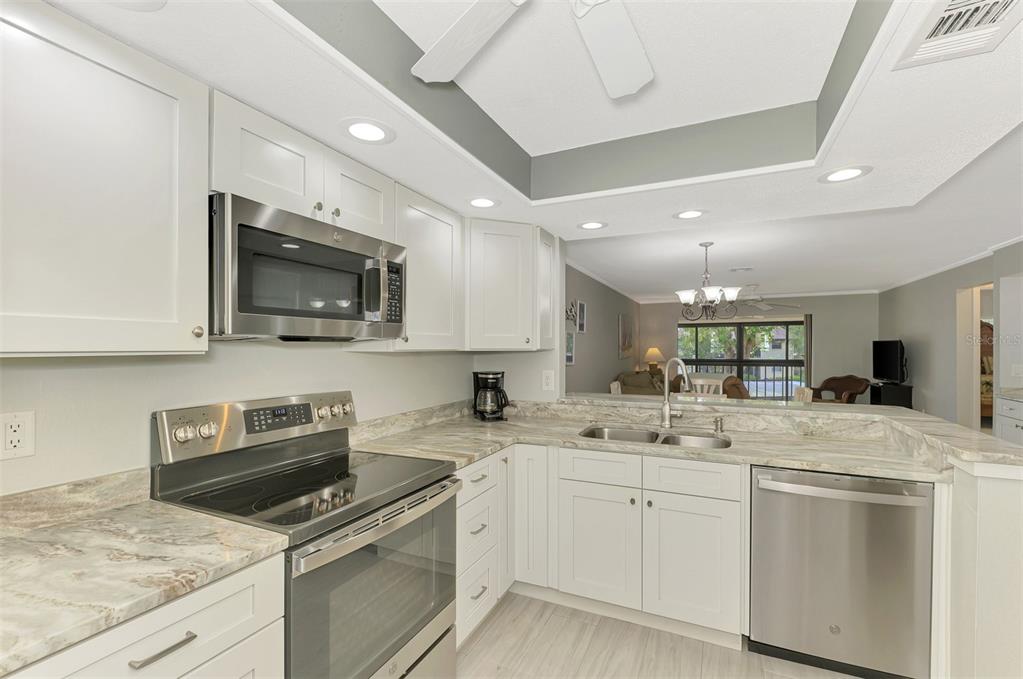 285 Mission Trail West, Unit B Venice, FL 34285 - Photo 8 of 49 a kitchen with a sink a stove and microwave