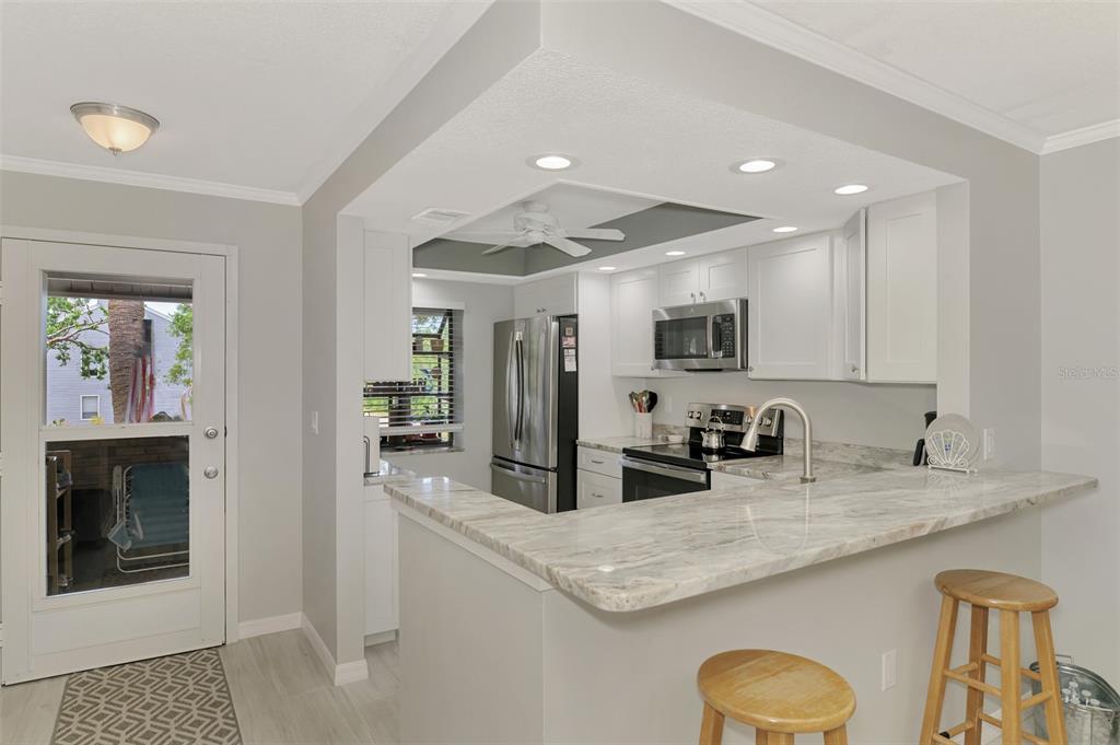 285 Mission Trail West, Unit B Venice, FL 34285 - Photo 9 of 49 a kitchen with granite countertop a sink a stove and cabinets