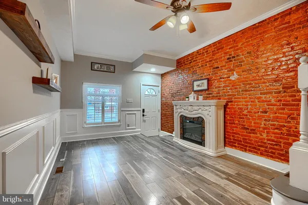 a view of front door with hallway and wooden floor