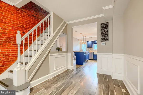 a view of a hallway with wooden floor and staircase