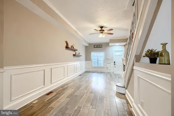a kitchen with stainless steel appliances granite countertop a refrigerator a sink dishwasher a stove and a dining table with wooden floor