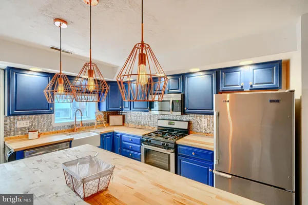 a kitchen with stainless steel appliances kitchen island granite countertop a kitchen island hardwood floor sink and stove