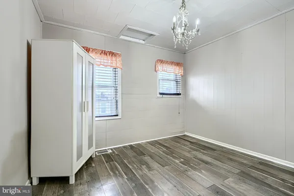 a view of a hallway with wooden floor and windows