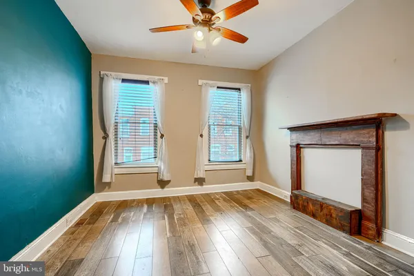 a view of a hallway with wooden floor and a bathroom
