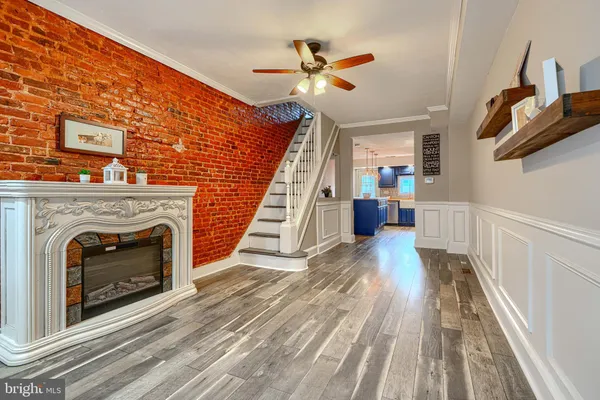 a view of a livingroom with wooden floor and a ceiling fan
