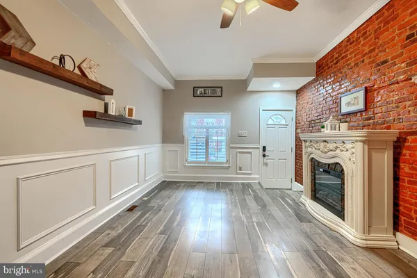 a view of empty room with fireplace and wooden floor