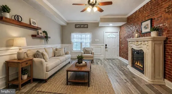 a view of an empty room with wooden floor fireplace and a window