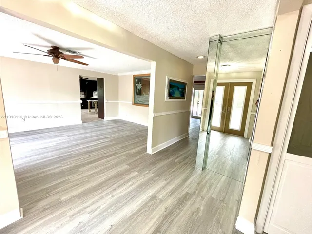 a view of a room with wooden floor and white walls