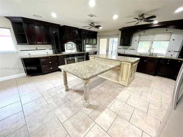 a kitchen with stainless steel appliances kitchen island granite countertop a sink and a stove