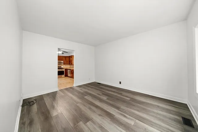 a view of an empty room and a kitchen
