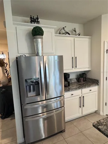 a kitchen with stainless steel appliances a refrigerator a stove and white cabinets