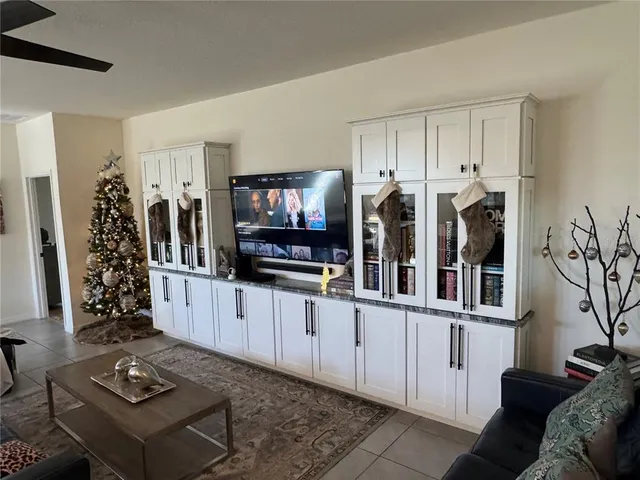 a living room with furniture a flat screen tv and a window