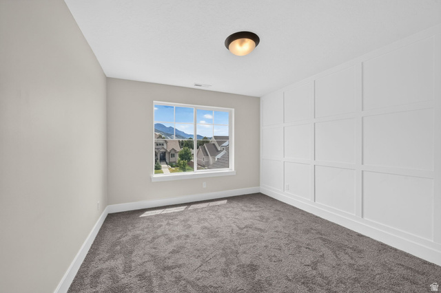 1002 West Temple Rim Lane Payson, UT 84651 - Photo 34 of 68 Room featuring an accent wall with wainscoting, white baseboards, and neutral wall paint
