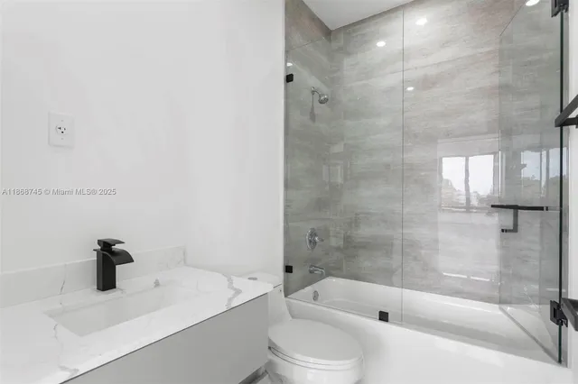 a white toilet sitting next to a bathroom sink