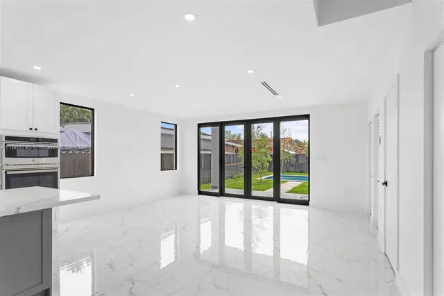a living room with stainless steel appliances furniture and a large window