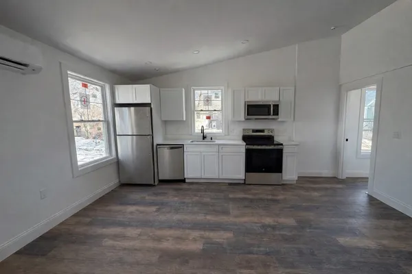 a kitchen with a refrigerator and a stove top oven