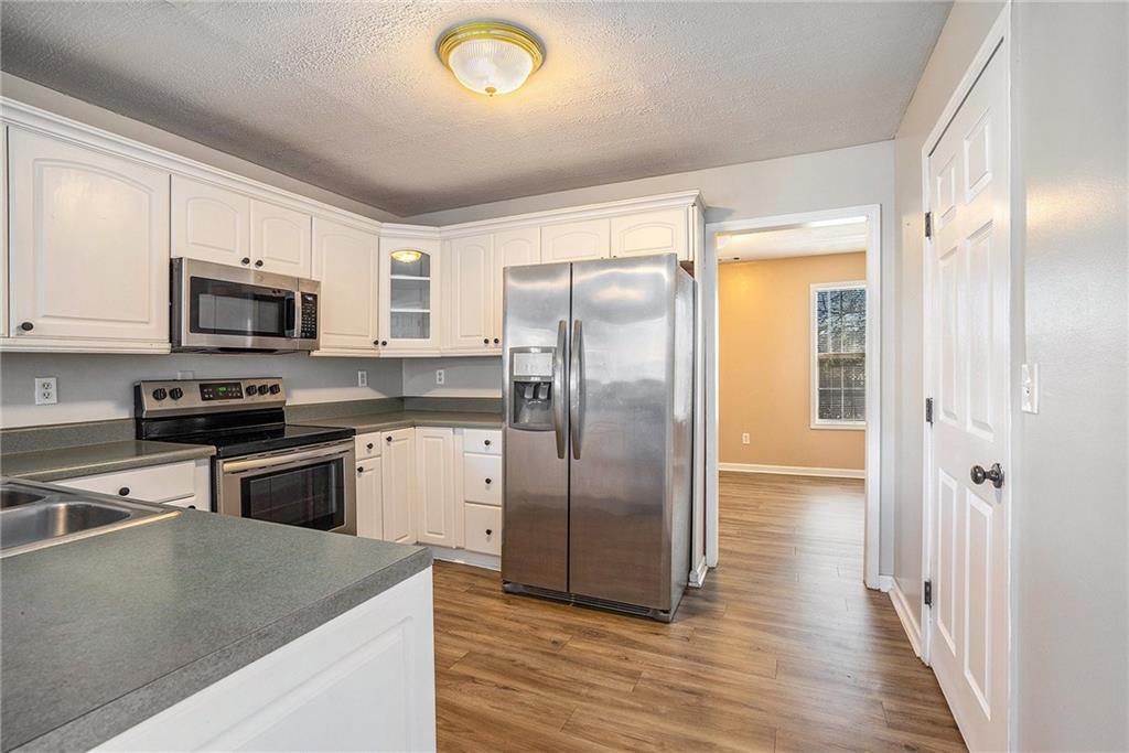 2000 Sage Court Loganville, GA 30052 - Photo 11 of 35 a kitchen with stainless steel appliances granite countertop a refrigerator a stove top oven a sink and dishwasher