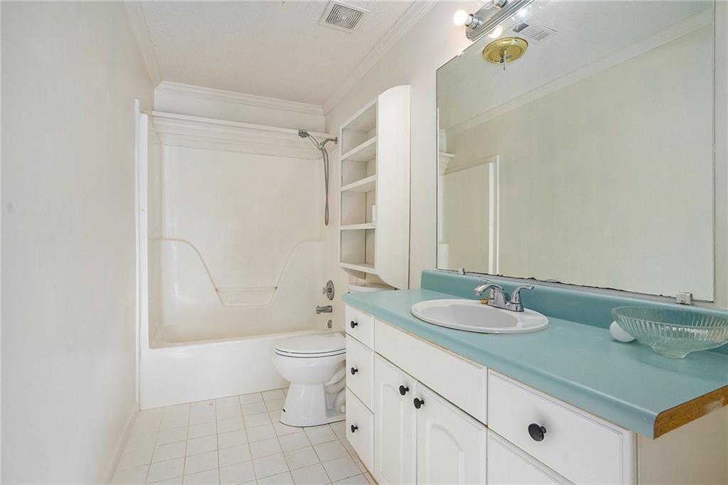 2000 Sage Court Loganville, GA 30052 - Photo 31 of 35 a bathroom with a granite countertop sink a toilet and a mirror