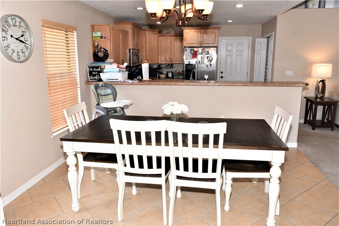 3535 Westminster Road Sebring, FL 33875 - Photo 9 of 27 a kitchen with a dining table chairs and a refrigerator