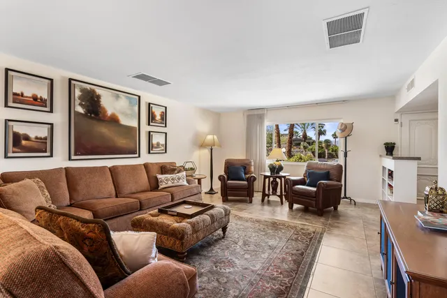 a living room with furniture two couch and a bookshelf