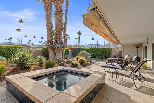 a view of swimming pool with outdoor seating and plants