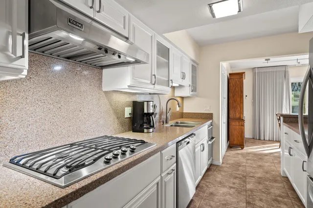 a kitchen with stainless steel appliances granite countertop a stove and a sink