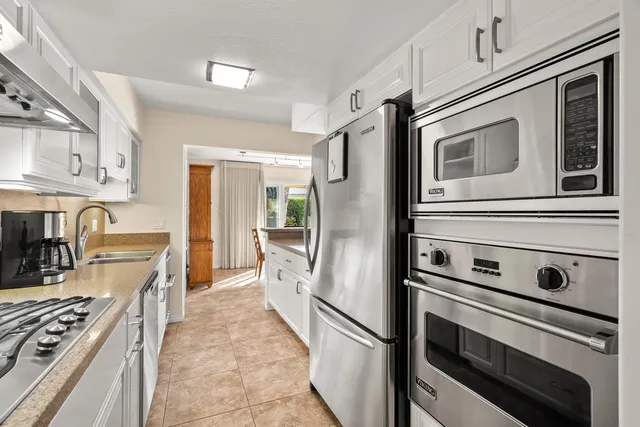 a kitchen with stainless steel appliances granite countertop a stove and a refrigerator