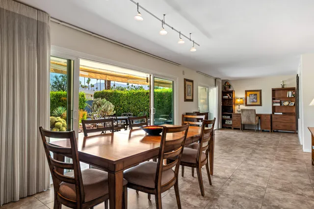 a dining room with furniture and a floor to ceiling window