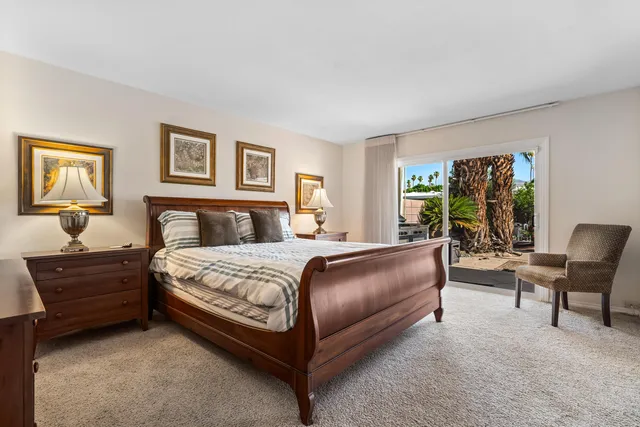 a bedroom with a bed chair and painting on the wall