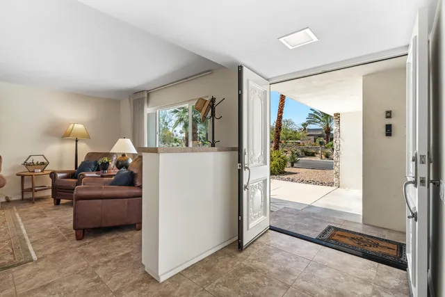 a living room with furniture and a floor to ceiling window