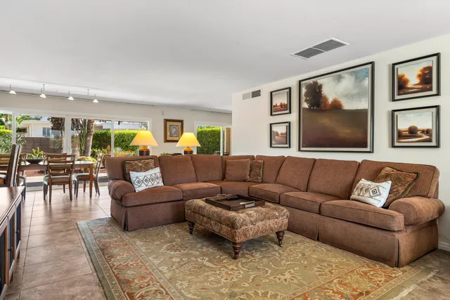 a living room with furniture and view of kitchen
