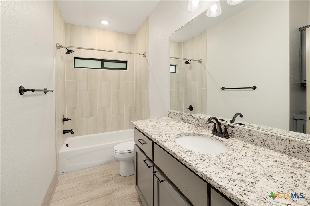 2892 Beulah Boulevard Belton, TX 76513 - Photo 23 of 39 a bathroom with a granite countertop sink a toilet and shower