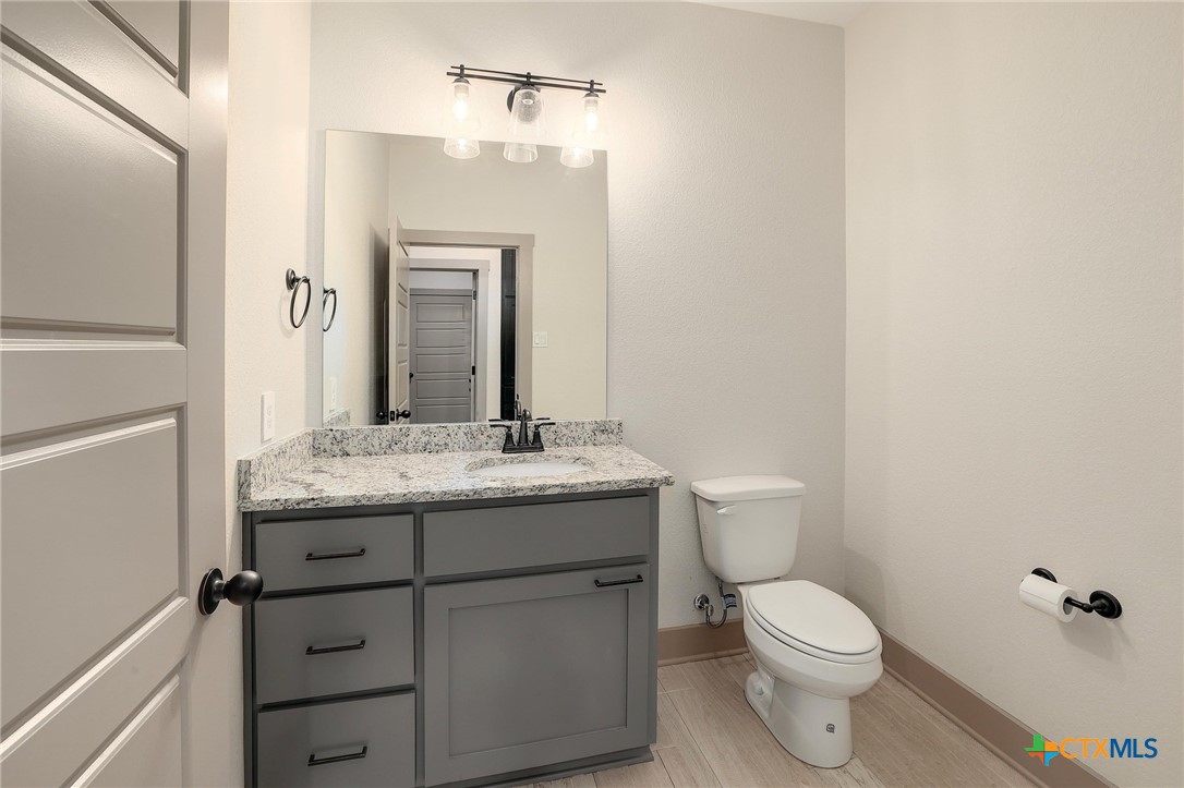 2892 Beulah Boulevard Belton, TX 76513 - Photo 24 of 39 a bathroom with a granite countertop toilet a sink and a mirror