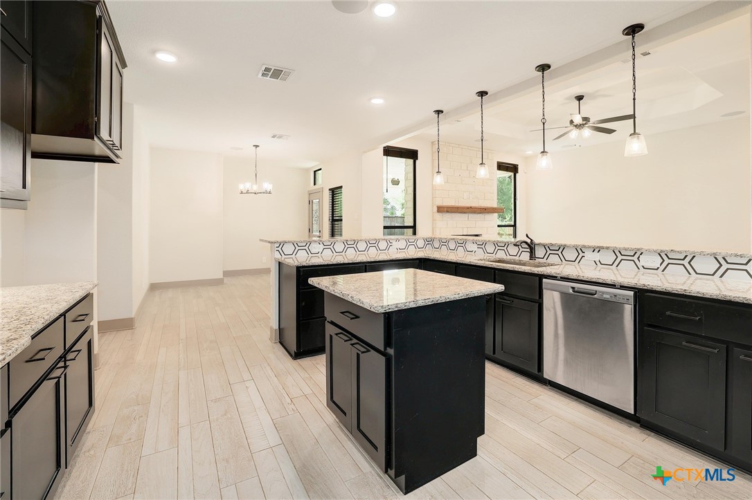2892 Beulah Boulevard Belton, TX 76513 - Photo 4 of 39 a kitchen with kitchen island granite countertop a sink stove and wooden floor