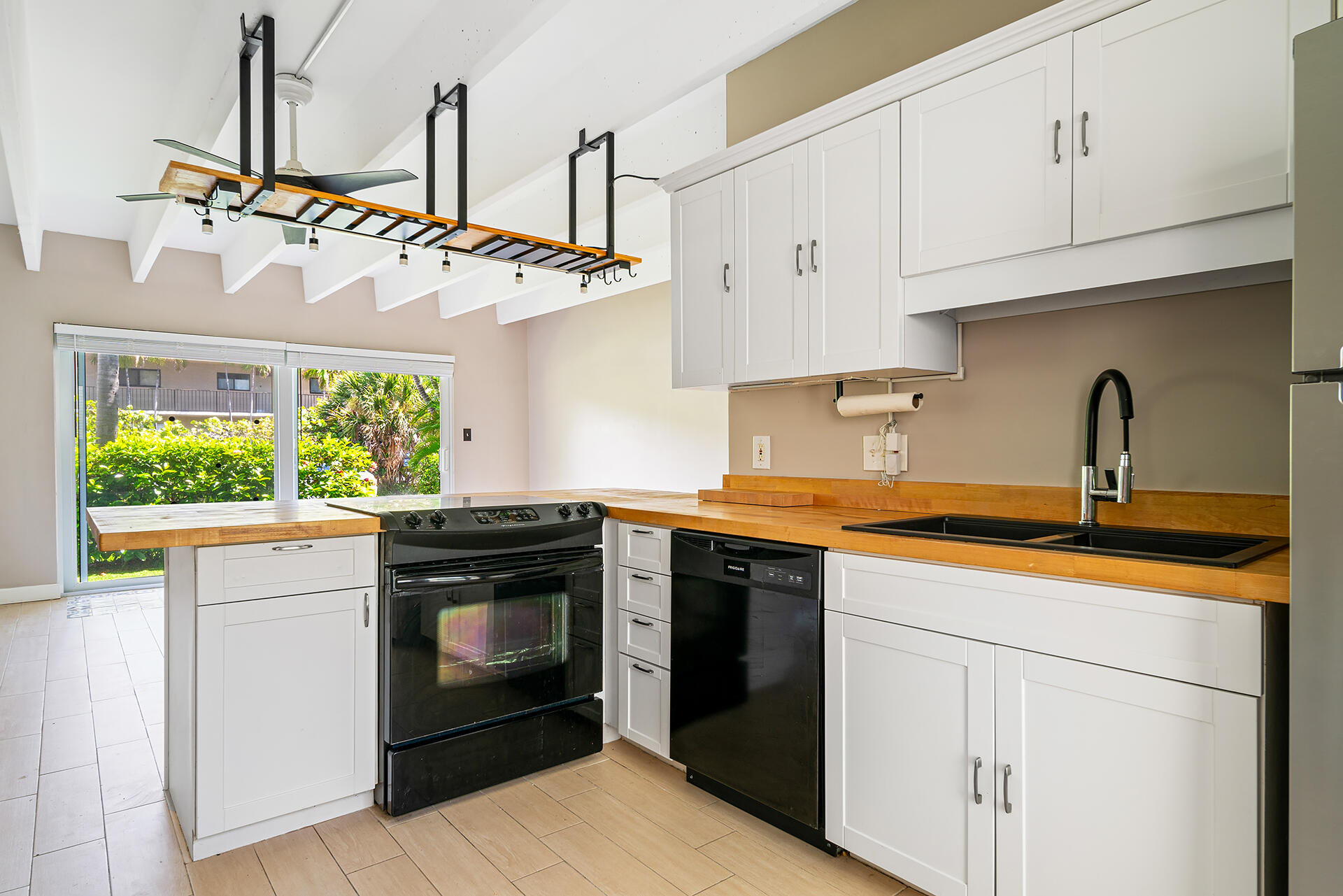 4001 South Ocean Boulevard, Unit 115 South Palm Beach, FL 33480 - Photo 8 of 25 a kitchen with stainless steel appliances granite countertop a stove a sink and a refrigerator