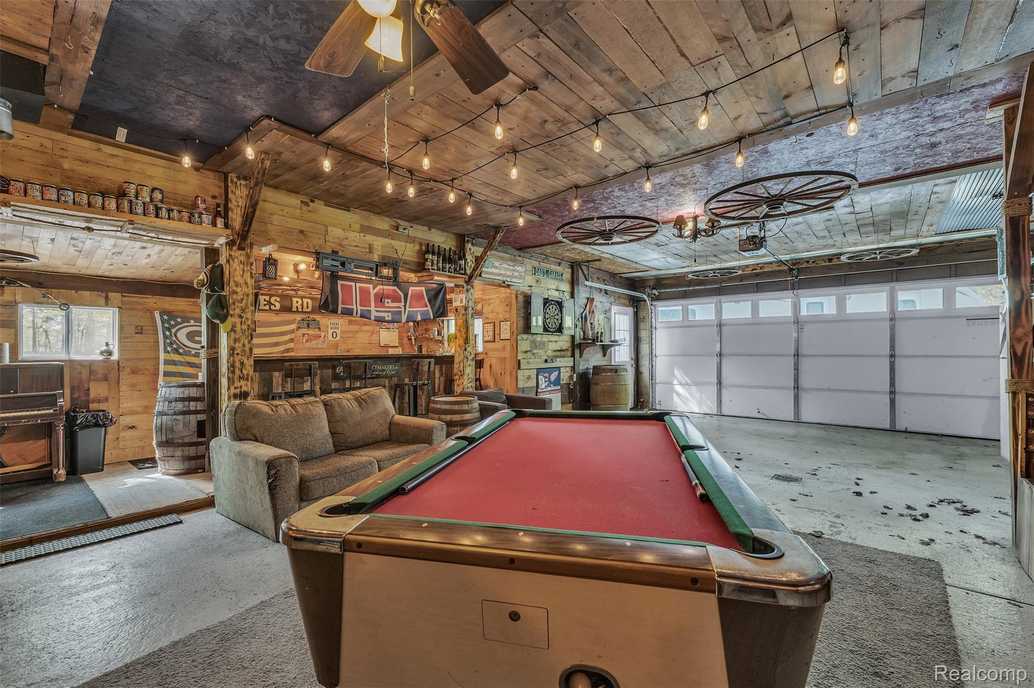 1345 Ives Road Mason, MI 48854 - Photo 52 of 92 Playroom with ceiling fan, a garage, pool table, rail lighting, and wood walls