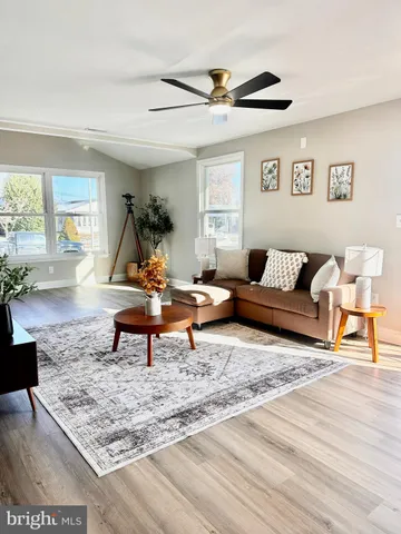 a living room with furniture and a wooden floor