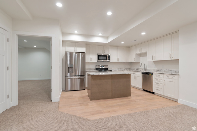 1820 West Farmhouse Flats Road Peoa, UT 84061 - Photo 40 of 79 Kitchen featuring white cabinetry, stainless steel appliances, a center island with a contrasting base, light-toned countertops, and wood-finish flooring