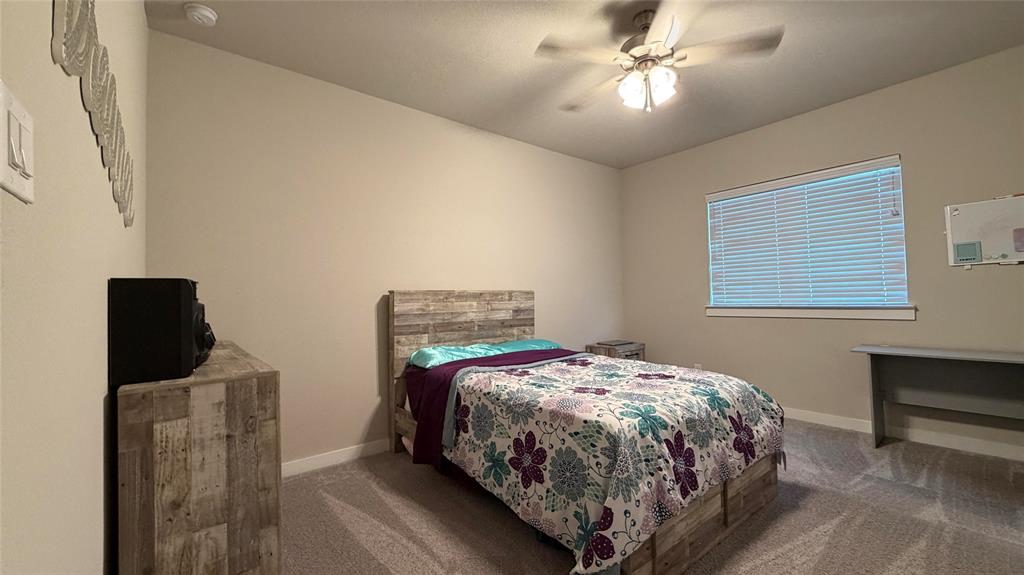 912 Fallbrook Avenue Denton, TX 76210 - Photo 20 of 26 a bedroom with a bed and a chandelier