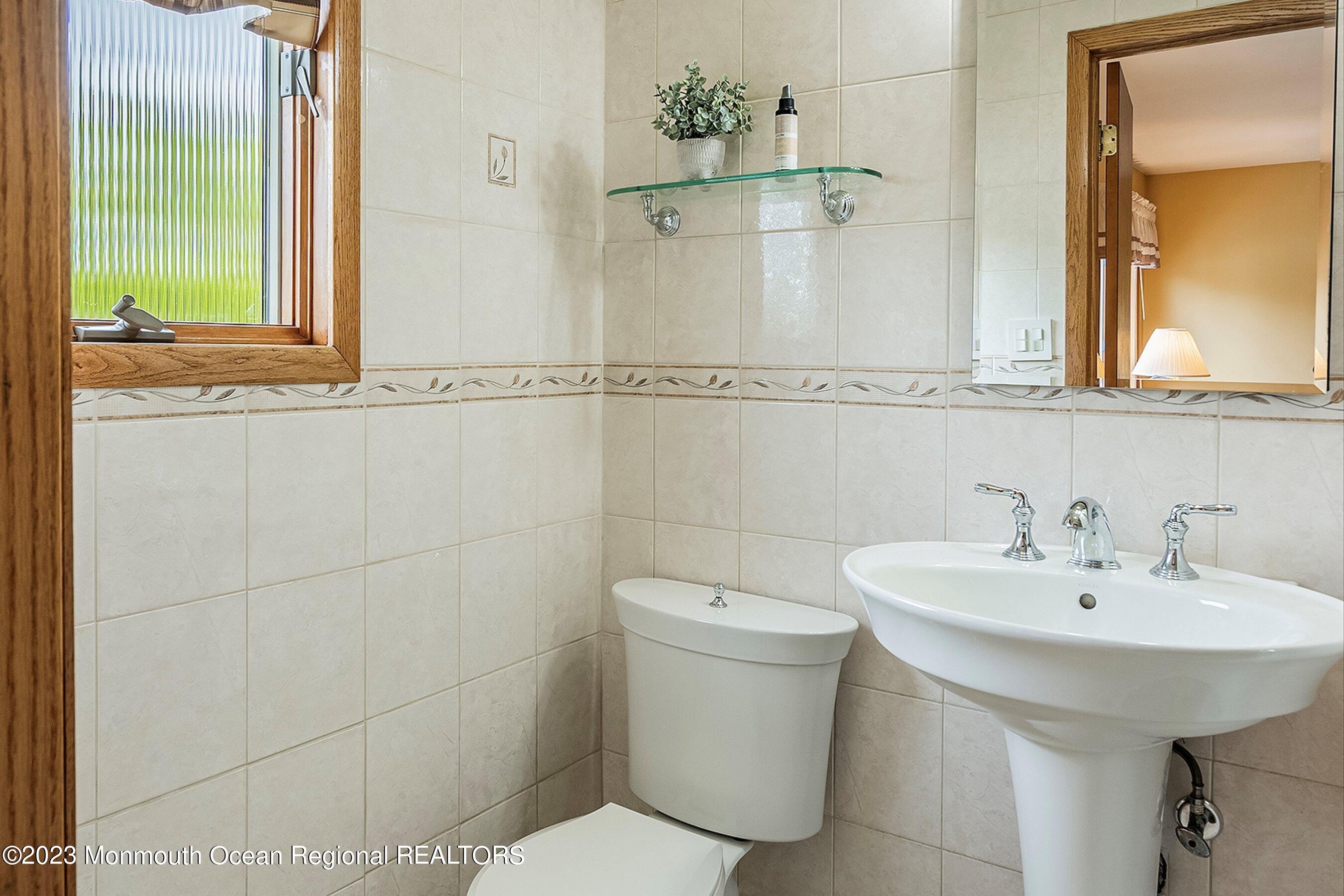 1 Hearth Court Howell, NJ 07731 - Photo 17 of 23 a bathroom with a sink a toilet and mirror